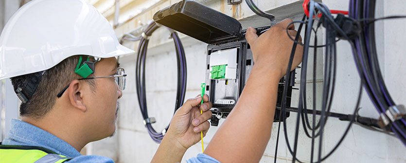 Certified Fiber Optic Technician installing fiber optic cables
